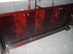 A large dark wood stained 4 door sideboard