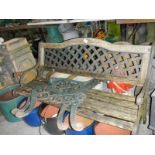 A cast iron bench with lattice back and a pair of benches