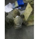 2 stone garden ornaments in the shape of acorns