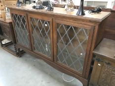An oak 3 door display cabinet with lead glass doors