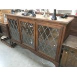 An oak 3 door display cabinet with lead glass doors