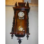 An Edwardian wall clock with relief hunting scene on pendulum.