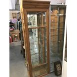 A pine display cabinet with bevel glass panels