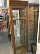 A pine display cabinet with bevel glass panels