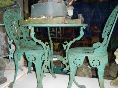 A cast iron aluminium table and two chairs