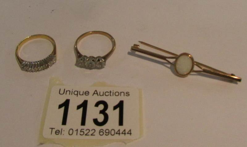 2 9ct gold rings set clear stones and a 9ct gold brooch.