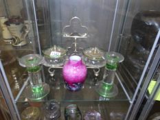 A pair of glass conserve pots on stand together with a pair of glass candlesticks and a vase.