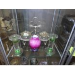 A pair of glass conserve pots on stand together with a pair of glass candlesticks and a vase.