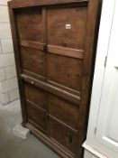 A vintage industrial pine cupboard with sliding doors