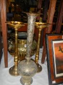 A brass jardiniere, a pair of brass candle holders and a brass vase.