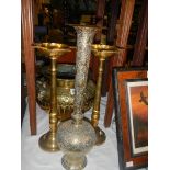 A brass jardiniere, a pair of brass candle holders and a brass vase.