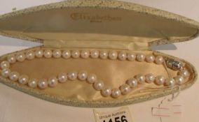 A cultured pearl necklace with large beads.