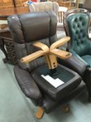 A brown leather recliner swivel chair & stool