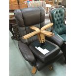 A brown leather recliner swivel chair & stool