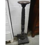 A Victorian black lacquered turned & carved wooden torchiere stand