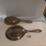 A silver backed hair brush and hand mirror.
