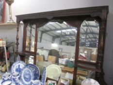 A large over mantle mirror in dark wood frame