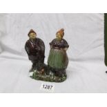 A glazed/treacle ware of a man and woman entitled 'Zebrugge-mole'.