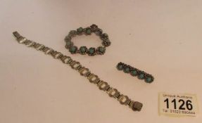A silver bracelet set with turquoise stone with matching brooch and another silver bracelet.