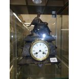 A cast iron mantel clock surmounted figure of a lady (working but needs servicing).