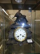 A cast iron mantel clock surmounted figure of a lady (working but needs servicing).