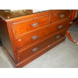 A mahogany chest of drawers with glass top.