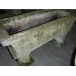 A large stone trough, decorated with lion heads,