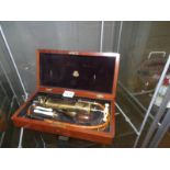 A cased brass medical instrument.