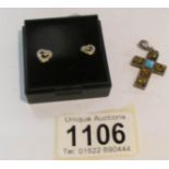 A pair of silver heart shaped ear studs and a silver stone set cross.