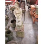 A stone staue of a lady on a base