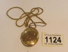 A 9ct gold locket (approximately 14 grams) on a yellow metal chain.
