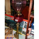 A Victorian brass and cranberry glass oil lamp.