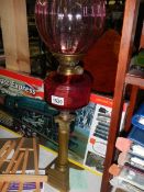 A Victorian brass and cranberry glass oil lamp.