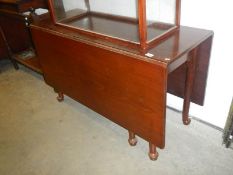 An Edwardian mahogany drop leaf dining table on pad feet