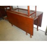 An Edwardian mahogany drop leaf dining table on pad feet