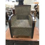 A dark wood stained wing armchair with cane panels