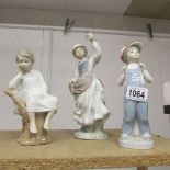 Three Lladro figurines being lady holding bird, boy reading and boy with accordion.