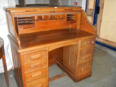 A 1930's oak double pedestal roll top desk