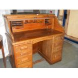 A 1930's oak double pedestal roll top desk