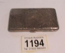 A silver card case with pencil.