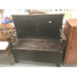 A dark oak monks bench