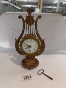 A Lyre shaped clock with key.