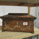 A Victorian rosewood tea caddy with mother of pearl inlay.