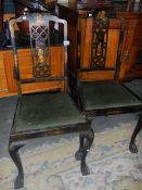 A pair of lacquered chairs.