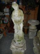 A stone statue of a lady on a pedestal