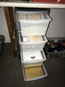 A 4 drawer plastic storage unit containing craft paper etc.