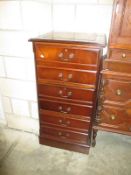 A dark wood stained wooden filing cabinet with leather insert top