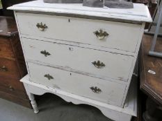 A shabby chic painted chest of drawers on stand