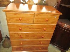 A modern polished pine chest of drawers