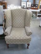 A wing armchair with classical style upholstery